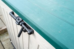 Large plastic weatherproof exterior storage chest used to store garden equipment. Showing detail of the locking system.