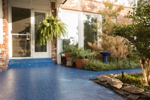 polyurea concrete blue patio with fern and other landscaping